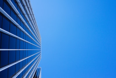 低角度摄影窗帘的玻璃建筑在蓝色的天空下
